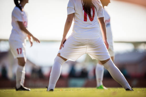 istock Back view of female soccer team stretching before the match. 958666482