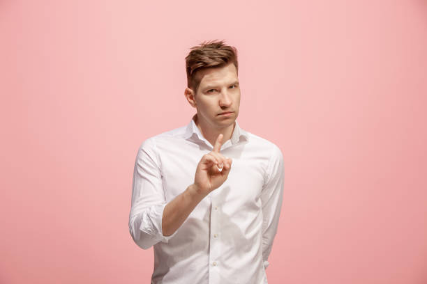 istock The young man whispering a secret behind her hand over pink background 958666562