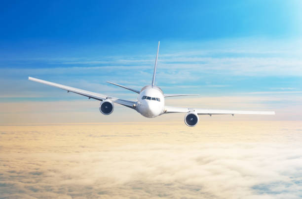 istock Passenger airplane flying at flight level high in the sky above overcast clouds and blue sky. 958666944
