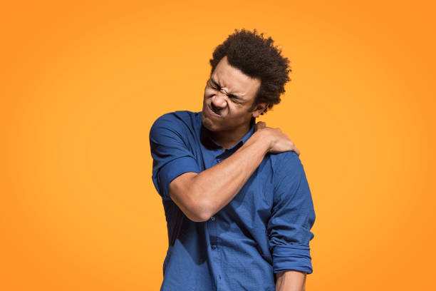 istock Young man overwhelmed with a pain in the shoulder 958669672