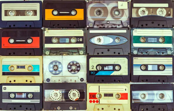 collection of various vintage audio cassettes. retro styled background