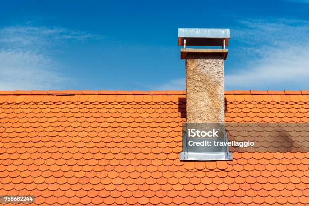 Modern Roof With Chimney Orange Ceramic Tile Shingle Blue Sky On The Background Stock Photo - Download Image Now