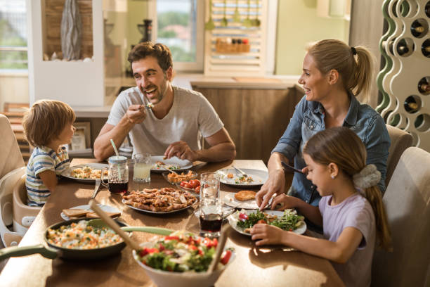 istock Happy family having fun while talking during lunch time in dining room. 958682738
