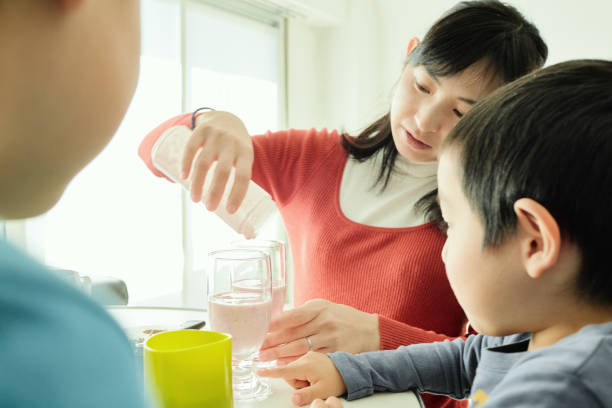 istock Young boys making smoothie with mother in home 958683286