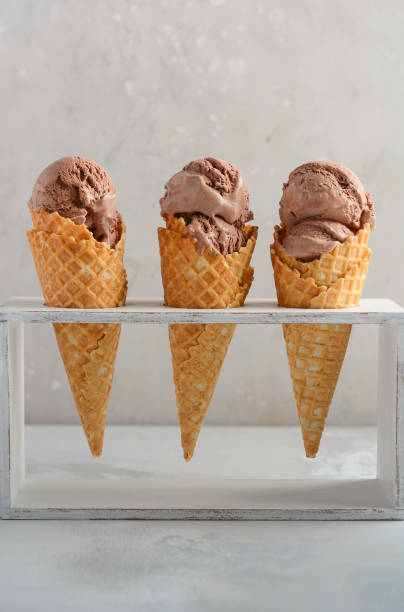 istock Chocolate ice cream in waffle cone on gray concrete background. 958686750