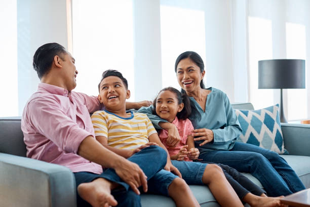 istock Happy family talking while sitting on sofa at home 958689854