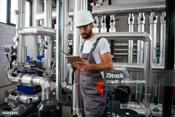Man Using Tablet At Natural Gas Processing Facility Stock Photo - Download Image Now