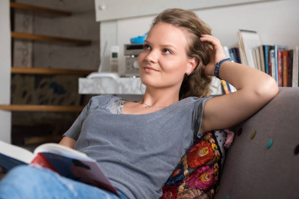istock Young woman reads a book at home 958692058