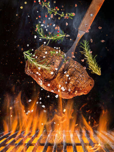 istock Tasty beef steak flying above cast iron grate with fire flames 958692628