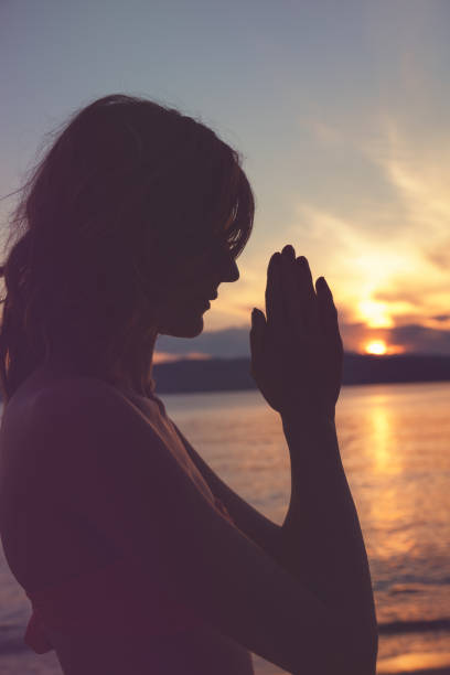istock Young woman practicing yoga on the beach. Praying concept. 958692960
