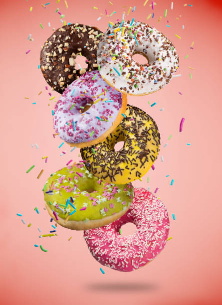 istock Tasty doughnuts in motion falling on pastel blue background 958693258