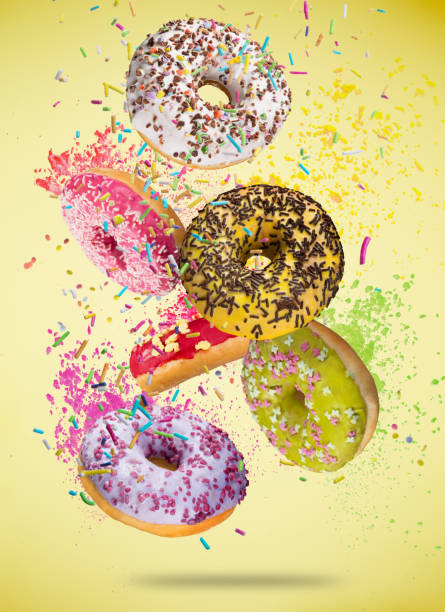istock Tasty doughnuts in motion falling on pastel blue background 958693314