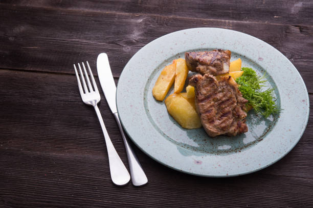 istock Tasty steak with potatoes on a blue plate 958694372