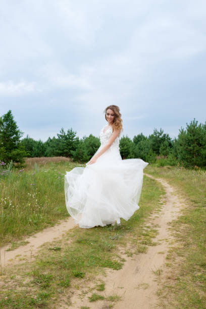 istock young pretty bride in white wedding dress spin around 958696490