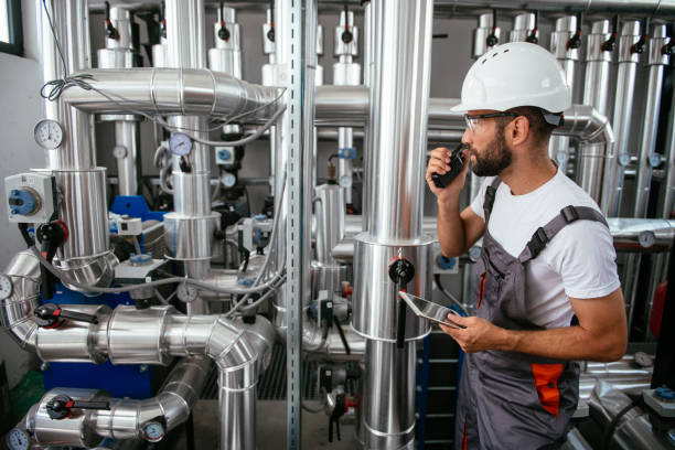 ingegnere in sala bollente con tablet e walkie-talkie - boiler fuel pump pipe engineering foto e immagini stock