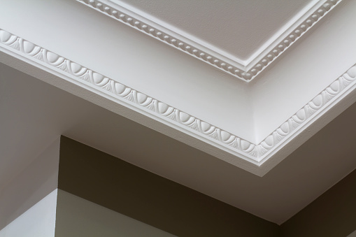 Blanco ornamental moldeado de la decoración en el techo de sala blanca primer plano detalle. Concepto de construcción y renovación interior. photo