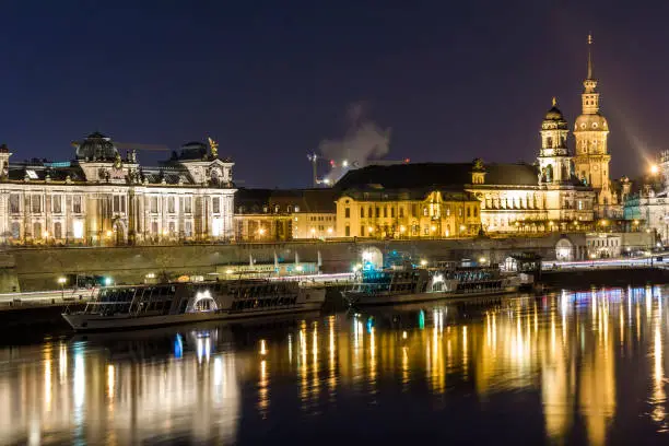 Photo of Night cityscape view of historic buildings with reflections in Elbe river in the center of Dresden (Germany).