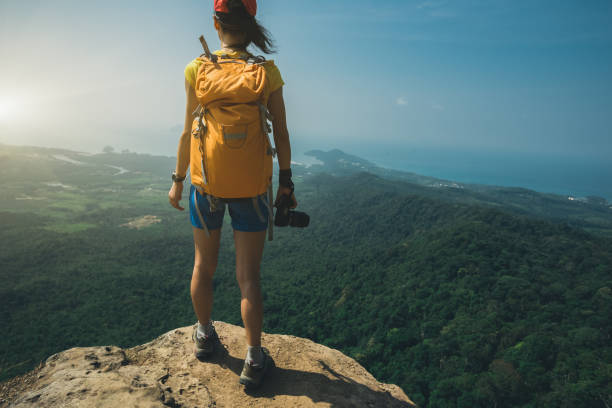 istock successful woman hiker stand on mountain peak cliff edge 958698114
