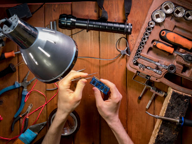 istock looking and learning and examining the electric board in the workshop over the table with tools 958698244