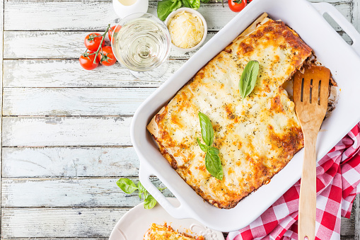 Traditional italian lasagna with vegetables, minced meat and cheese. On a wooden background. Top view, copy space