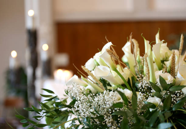 flowers on an altar in the church and the candles on background vase of flowers on an altar in the church and the candles on background funeral stock pictures, royalty-free photos & images