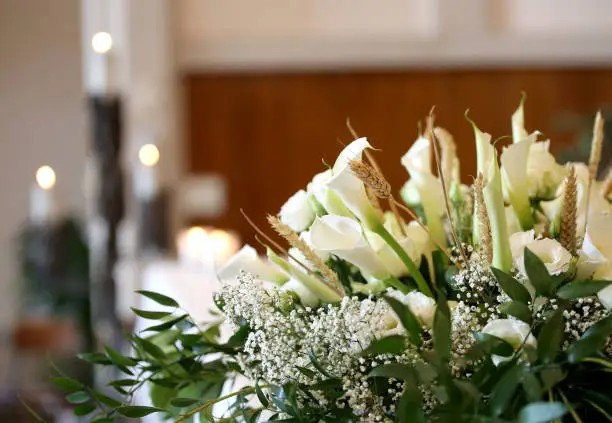 Photo of flowers on an altar in the church and the candles on background