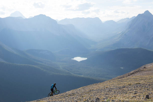 istock Mountain biker traverses high mountain ridge crest 958704508