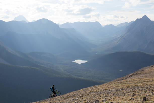 istock Mountain biker traverses high mountain ridge crest 958704530