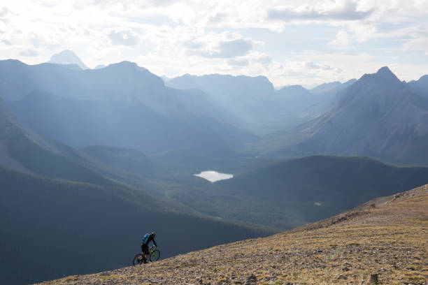 istock Mountain biker traverses high mountain ridge crest 958704556