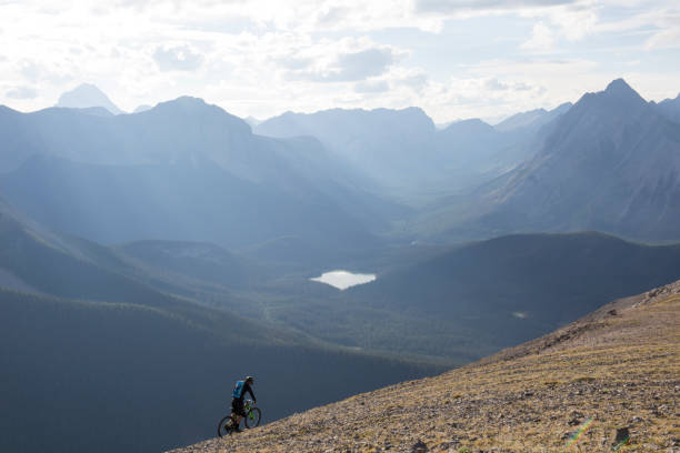 istock Mountain biker traverses high mountain ridge crest 958704560