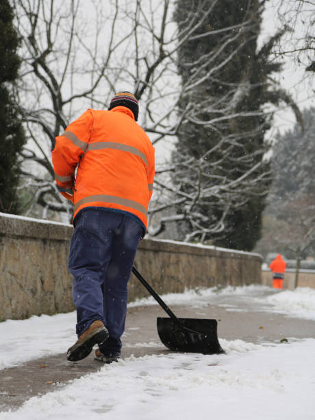 istock scavenger shovels snow from the sidewalk after the snowfall 958707530