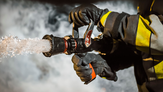 Close-up of firefighter using extinguisher after accident.