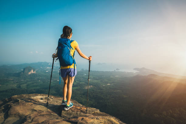 istock successful woman hiker stand on mountain peak cliff edge 958710186