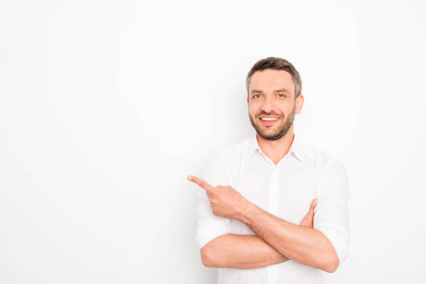 istock Cheerful young man gesturing with hand and showing way 958713428