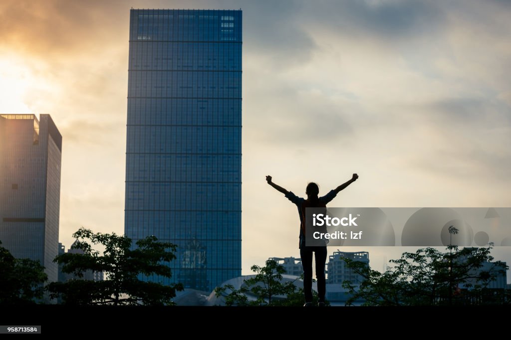 Young successful woman standing with arms open in city Businesswoman Stock Photo