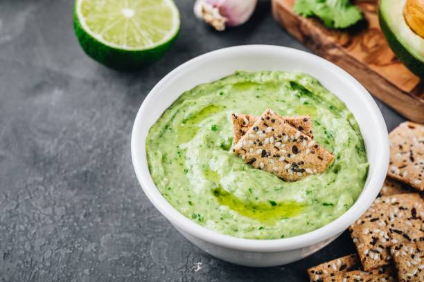 dip de aguacate con cilantro y lima - avocado lemon snack cracker fotografías e imágenes de stock