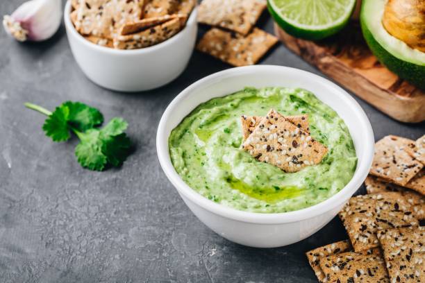 Avocado dip with cilantro and lime Creamy avocado dip with cilantro and lime hummus stock pictures, royalty-free photos & images