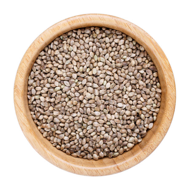 istock Hemp seeds in wooden bowl isolated on white. Top view. 958714324
