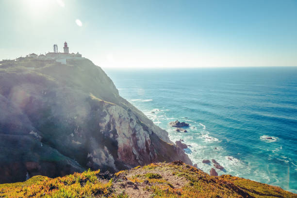 istock Scenic landscape with lighthouse at the Cabo da Roca, a cape which forms the westernmost extent of mainland Portugal 958716832