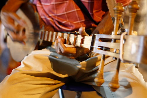 Asian man playing stringed instrument, busking at a local market, Northern Thailand, Southeast Asia