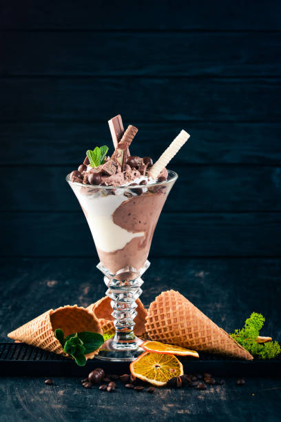 istock Ice cream with milk chocolate. On a black wooden background. Copy space. 958719546