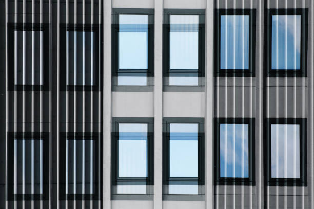 istock Louvered windows reflecting sky and clouds. Digitally rendered image of futuristic office building midsection. Abstract image on the subject of modern architecture or eco-friendly technologies. 958719736