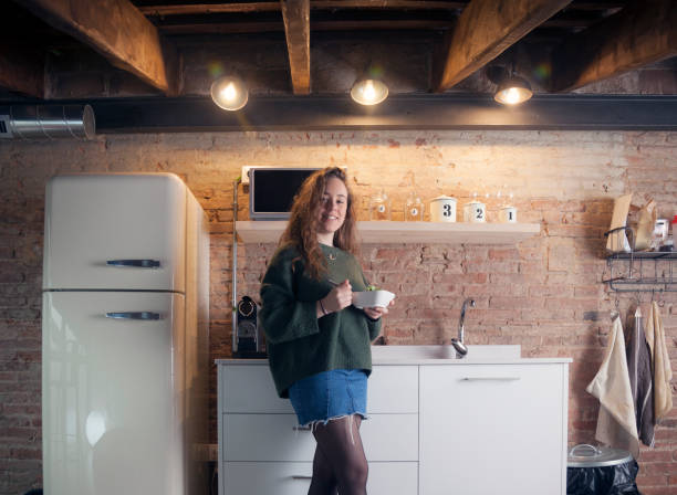istock Beautiful girl eating salad in a modern kitchen 958720172