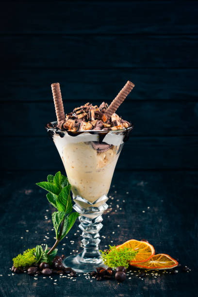 istock Ice-cream with caramel and nuts. On a black wooden background. Copy space. 958721966