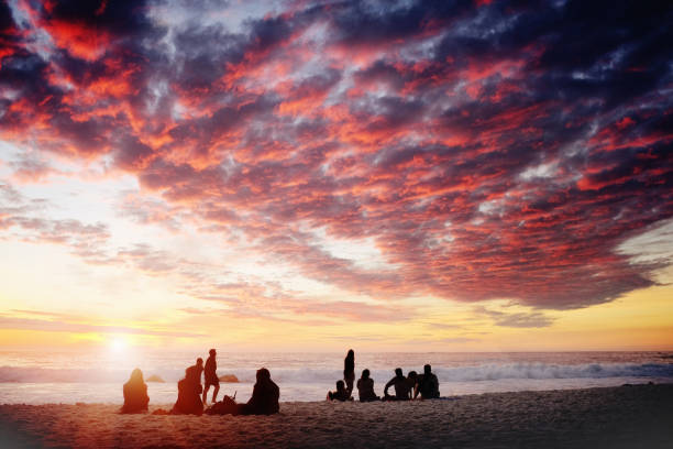 istock Red sky at night: picnickers on beach at sunset 958722470