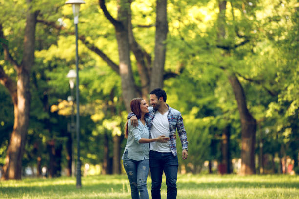 istock Affectionate young couple walking in a park 958723194