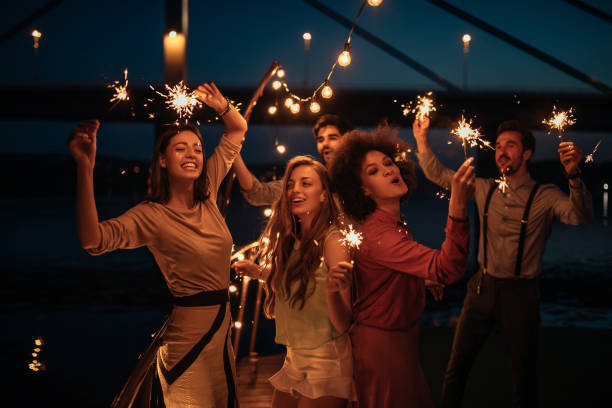 Having best times of their lives Group of friends holding sprinklers on a boat cruise party social event stock pictures, royalty-free photos & images
