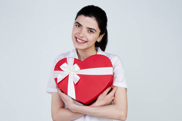 istock Young woman holding heart shape gift box 958727722