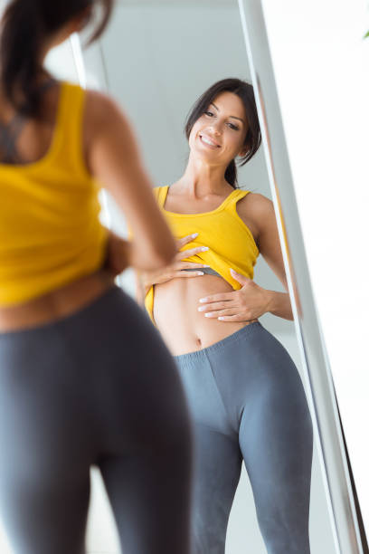 istock Beautiful young woman looking herself reflection in mirror at home. 958728070
