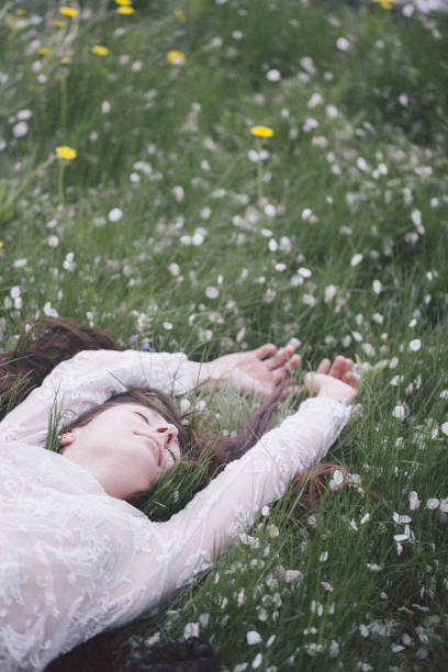 istock Young woman lying in grass 958728318